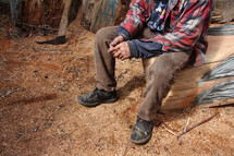 wood worker resting on a log 