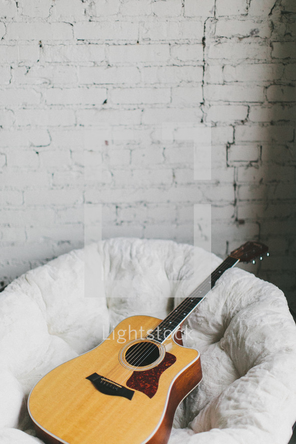 guitar resting in a bucket chair