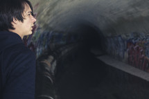 man looking down a long dark tunnel 