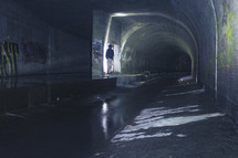 man standing in a tunnel 