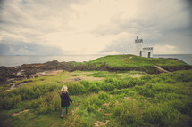 woman walking up to a lighthouse 