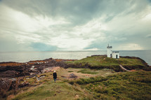 woman walking up to a lighthouse 