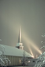 spotlights on a church in winter snow 