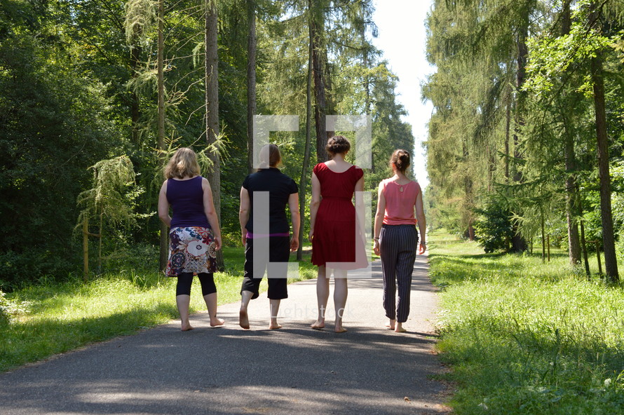 four friends walking on a path outdoors 