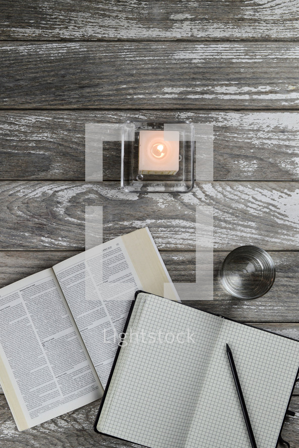 candle, notebook, Bible and glass 
