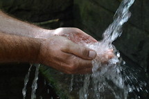 a man washing his hands under water 