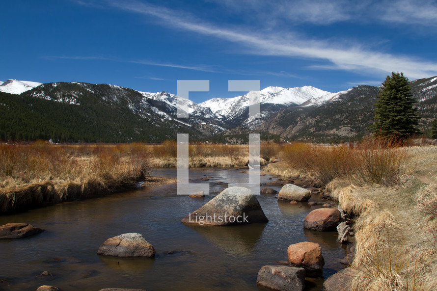 stream and snow capped mountain peaks