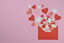 red and pink hearts in an red envelope with copy space to the left