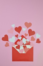 red and pink hearts in a red envelope with copy space above