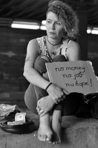 a homeless woman holding a sign - no money no job no hope 