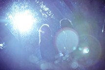 Sunlight beaming on silhouette of two girls talking in a park.