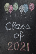 chalk on slate with balloons and the words: class of 2021