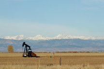 oil rig in front of mountains 