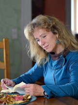 woman sitting at a table reading a Bible 