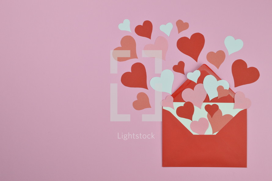 red and pink hearts in an red envelope with copy space to the left