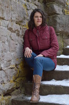 a woman sitting on snowy steps 
