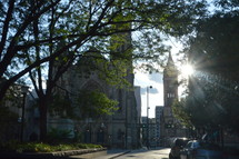 sunburst through the trees and a city church 