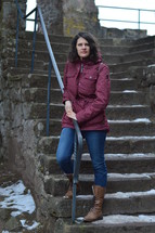 a woman standing on snowy steps 