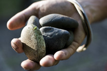 hand holding five smooth stones 