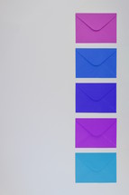 blue, purple, and fuchsia envelopes 