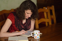 woman sitting at a table reading a Bible 