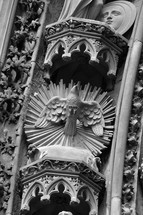 The Holy Spirit in the symbol of a dove at a cathedral entrance portal. 