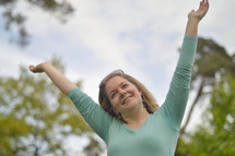 smiling woman with raised arms 