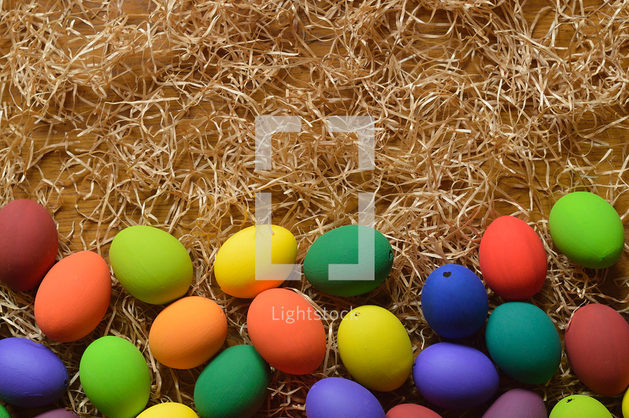 Colorfully painted Easter egg border on straw.
