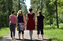 four friends walking on a path outdoors 