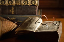 reading glasses on the pages of an old book 