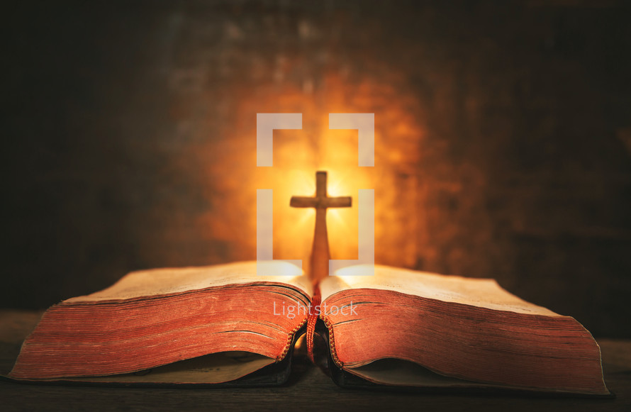 glowing cross and open Bible 