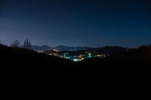 lights from a town in a valley at night 