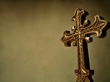 A dark gold cross used for Good Friday and Easter church services