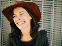 A laughing young woman in a red hat.
