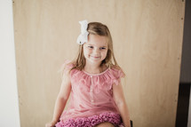 girl child sitting on a stool smiling 