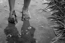 The feet of a child walking in mud