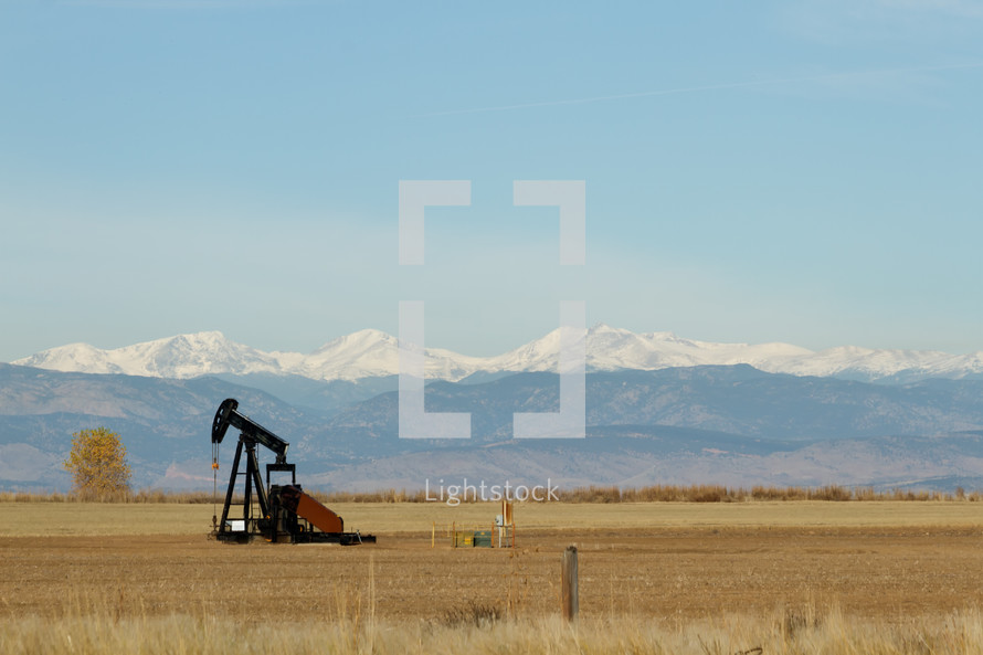 oil rig in front of mountains 