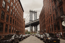 Brooklyn bridge and cars parked on a narrow street 