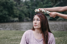 placing a crown of flowers on a woman's head 