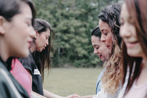  young women holding hands in prayer 