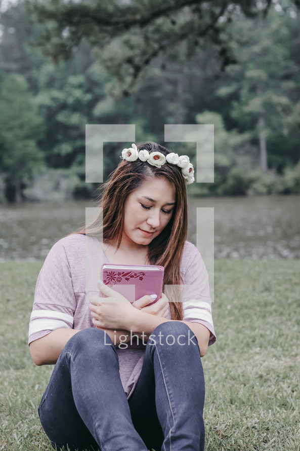 a woman with flowers in her hair holding a Bible 