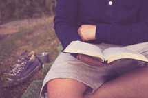 torso man reading a Bible outdoors 