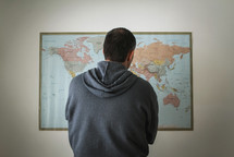 a man standing in front of a world map 