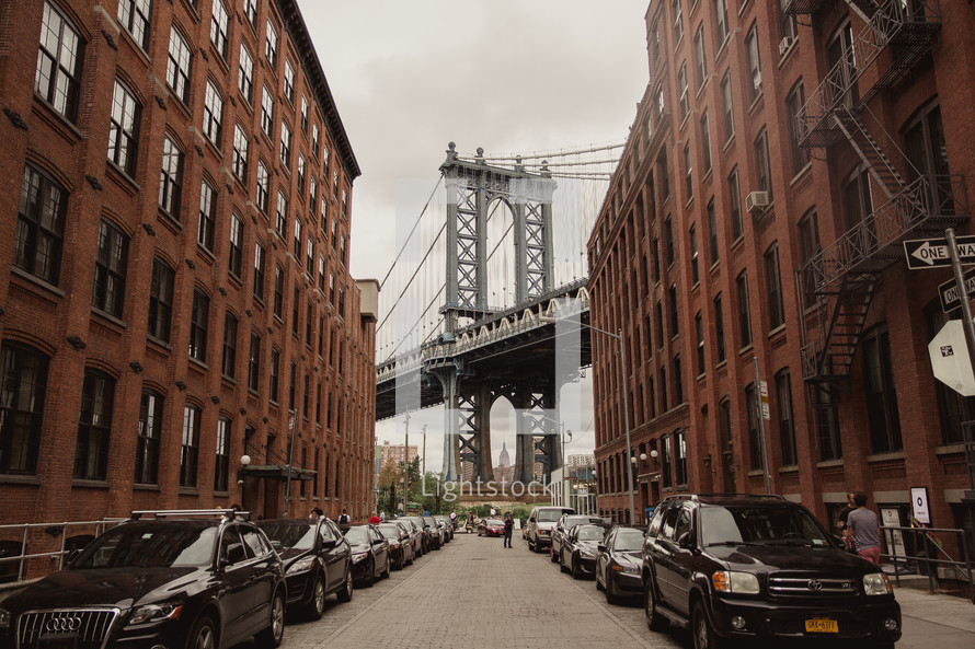 Brooklyn bridge and cars parked on a narrow street 