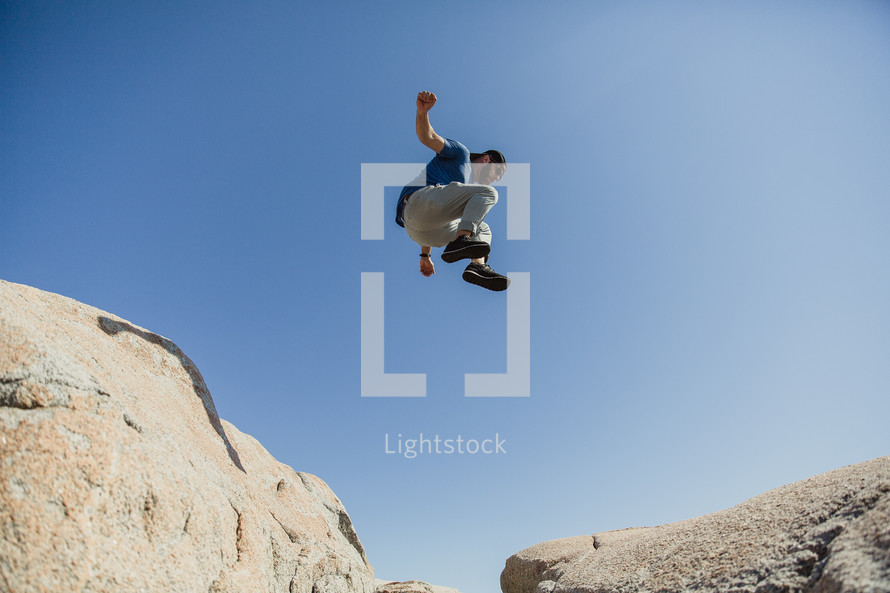a man leaping over rocks 