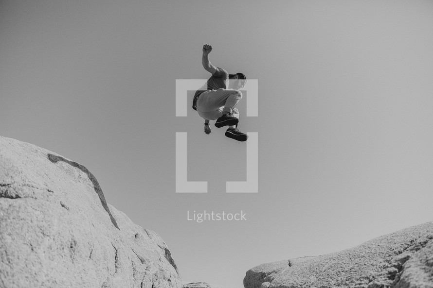 man leaping over rocks 