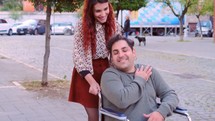 a woman pushing a man in a wheelchair 