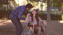 a man having a conversation with a woman in a wheelchair 