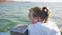 Young Girl Gazing Into The Water From A Slowly Moving Boat