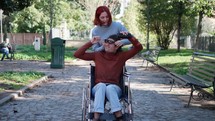 Guy in a wheelchair and girl listening to music and dancing. 